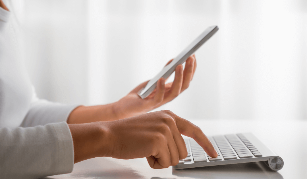 A woman types a code from her phone into her laptop, using 2 factor authentication.